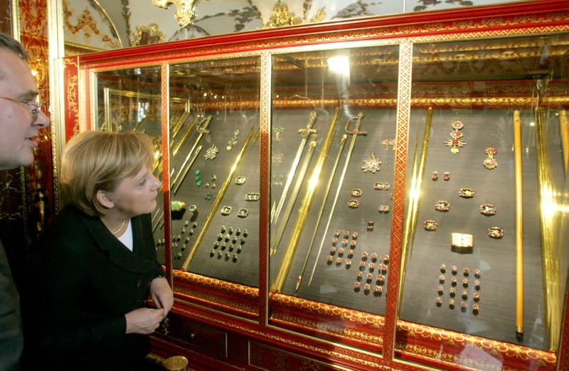 FILE PHOTO: German Chancellor Merkel stands beside museum director Syndram during her visit to the Gruenes Gewoelbe in Dresden