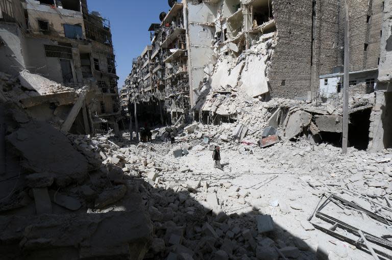A man walks through the rubble following reported air strikes by government forces on the eastern Shaar neighbourhood of the northern Syrian city of Aleppo on March 27, 2015