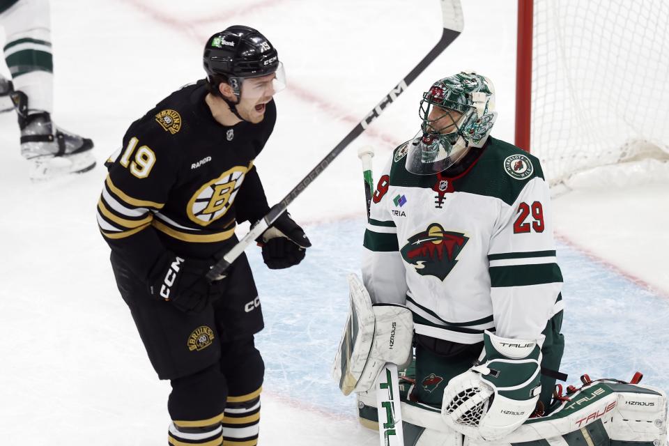 Boston Bruins' Johnny Beecher (19) celebrates the first goal by David Pastrnak (88) in the first period in front of Minnesota Wild's Marc-Andre Fleury (29) during an NHL hockey game, Tuesday, Dec. 19, 2023, in Boston. (AP Photo/Michael Dwyer)