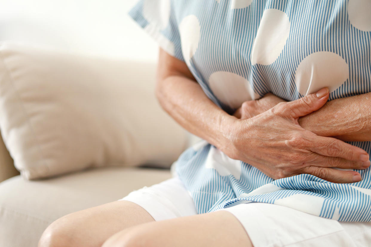 Midsection of a senior Asian woman having painful stomachache, chronic gastritis, Abdomen bloating concept