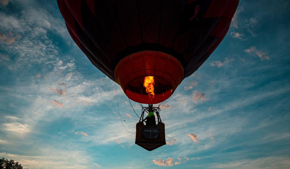 Pilot Michael Scott takes flight in his hot air balloon during the morning balloon glow and flights for the FireLake Fireflight Balloon Fest in Shawnee Okla. on Friday, Aug. 13, 2021.