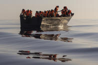 Migrants with life jackets provided by volunteers of the Ocean Viking, a migrant search and rescue ship run by NGOs SOS Mediterranee and the International Federation of Red Cross (IFCR), still sail in a wooden boat as they are being rescued Saturday, Aug. 27, 2022, some 26 nautical miles south of the Italian Lampedusa island in the Mediterranean sea. 87 survivors, including 3 women, 25 minors were rescued in the rescue operation. (AP Photo/Jeremias Gonzalez)