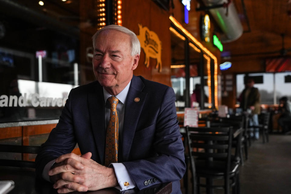 Former Gov. of Arkansas Asa Hutchinson talks to a reporter at Jethro's BBQ 'n Bacon in West Des Moines on Wednesday, March 29, 2023.