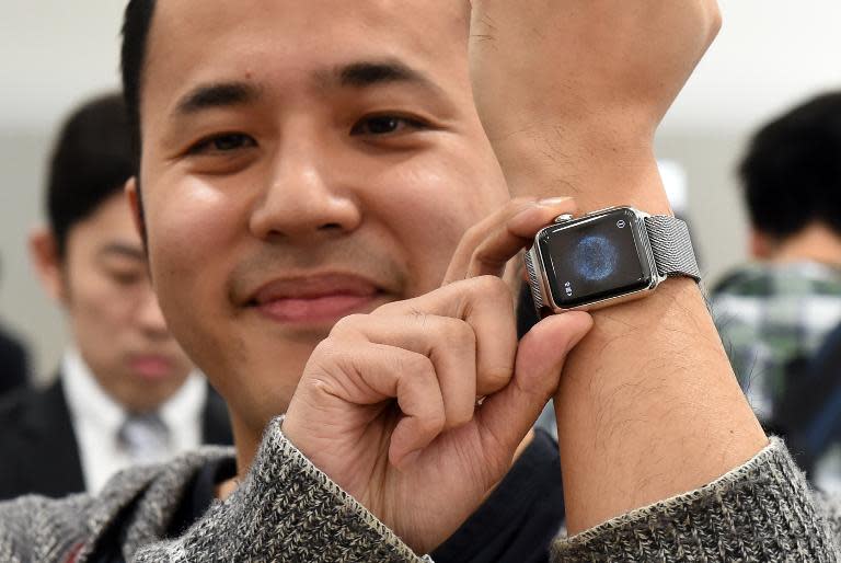 Yuichiro Masui, the first Apple Watch customer at a telecom shop in Tokyo's Omotesando area, poses with his new purchase on April 24, 2015