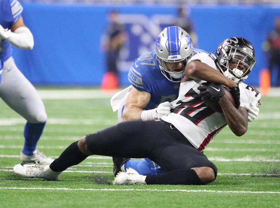 Lions defensive end Aidan Hutchinson tackles Atlanta Falcons running back Qadree Ollison (30) during the first half of a preseason game Aug. 12, 2022 at Ford Field.