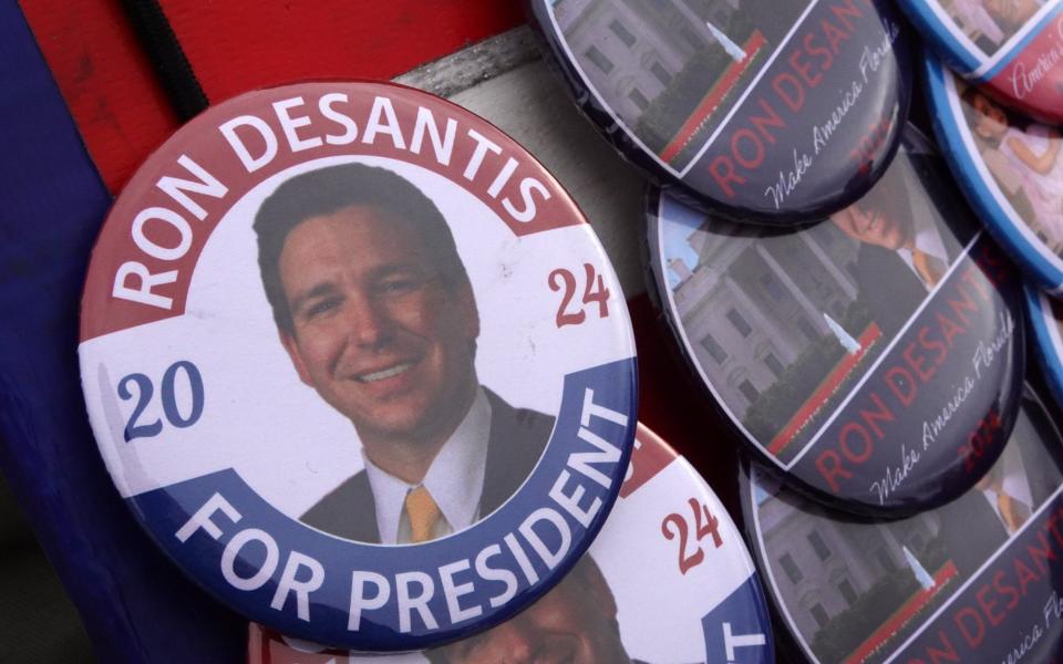 A vendor sells buttons as people wait in line to hear the Florida governor speak - Scott Olson