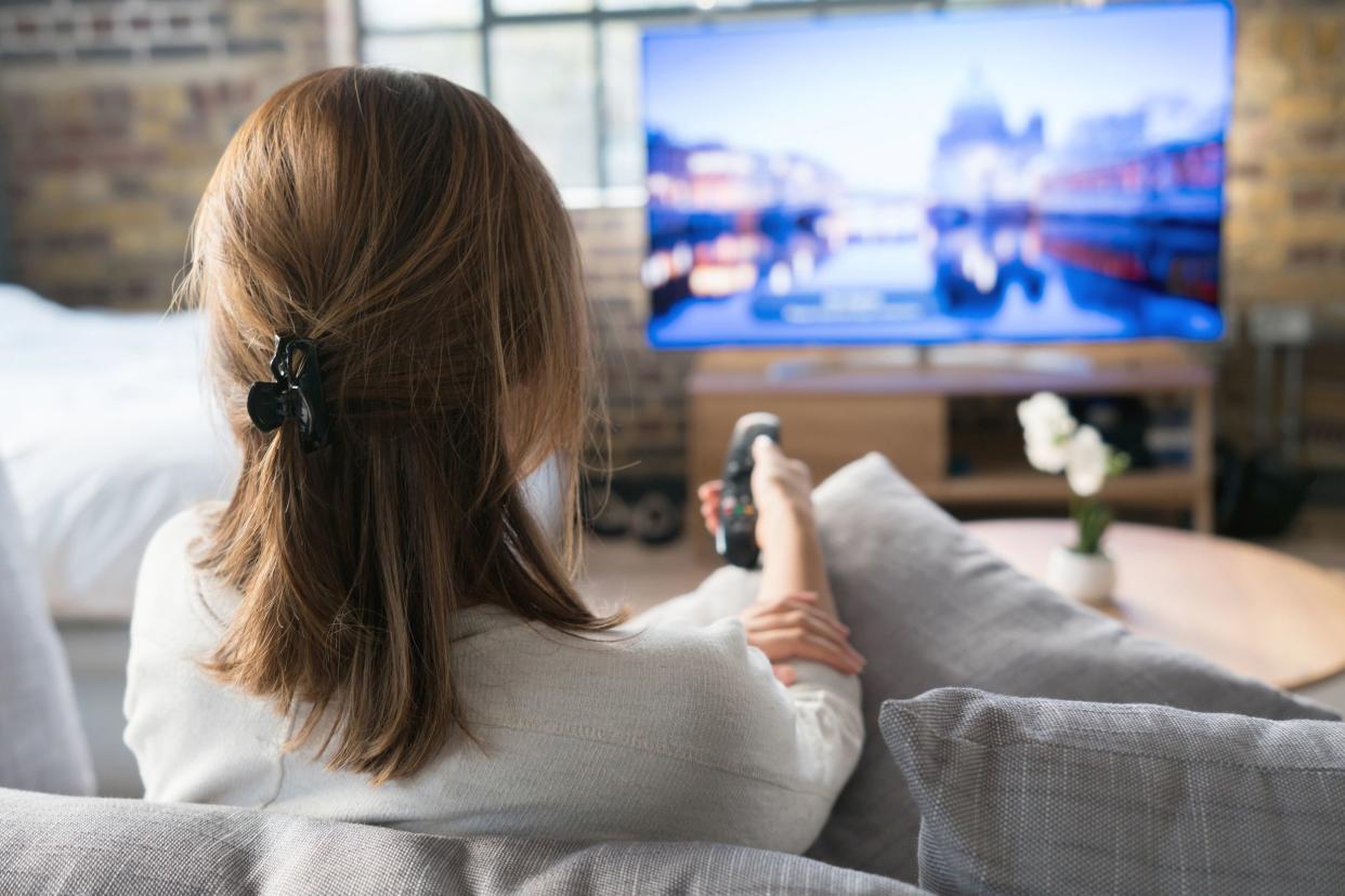 view of backside of woman watching tv at home