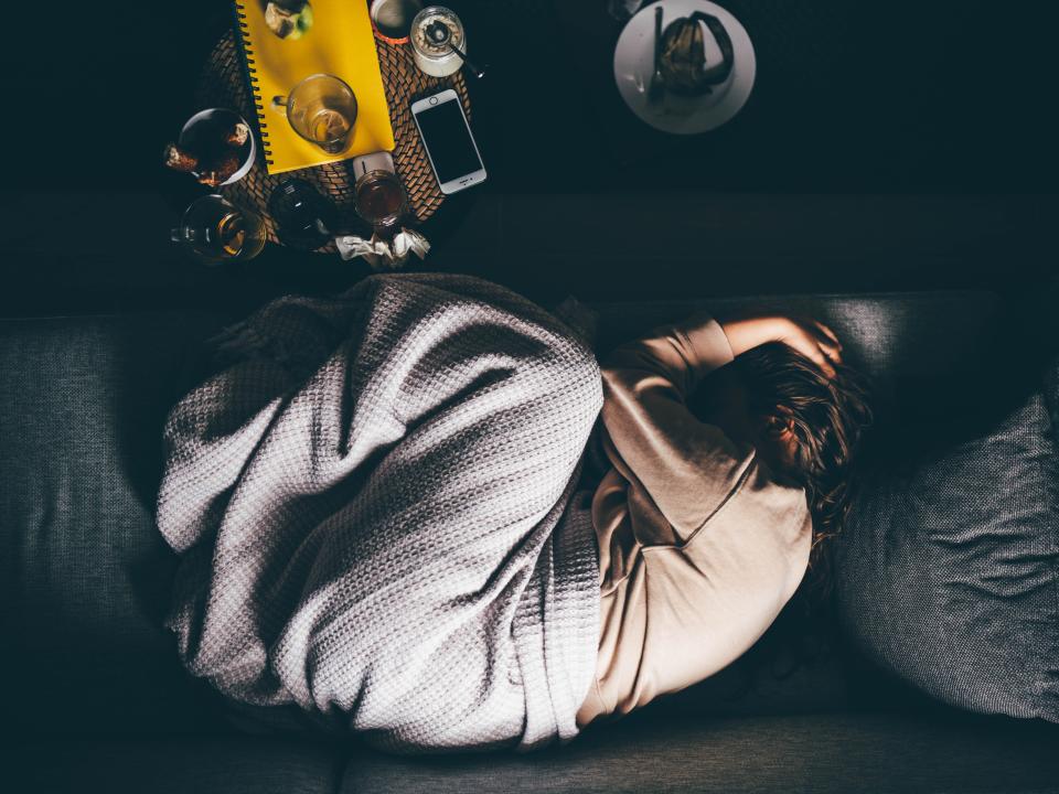 Worried young woman lying on sofa at home