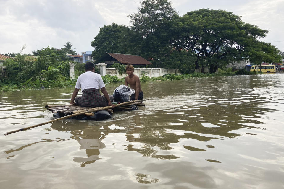 A volunteer pushes a man on a raft made with inner-tubes along a flooded road in Bago, Myanmar, about 80 kilometers (50 miles) northeast of Yangon, Friday, Aug. 11, 2023. (AP Photo)