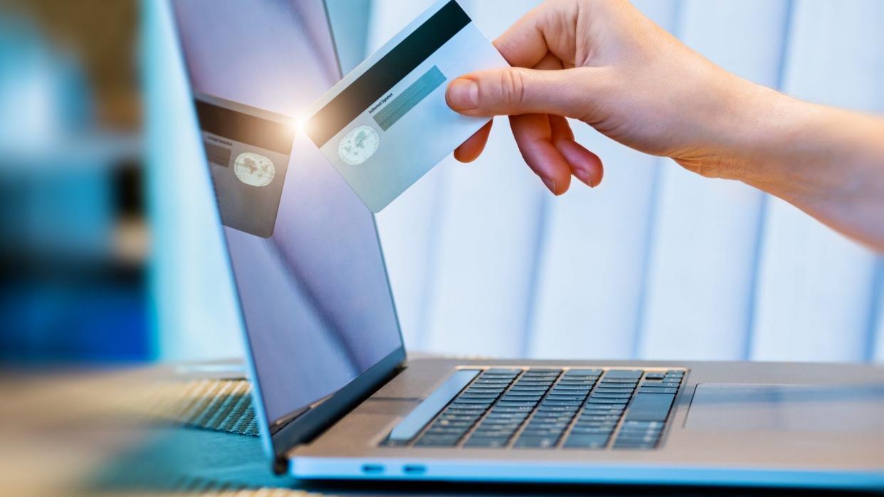 female hand with credit card and online payment using laptop.