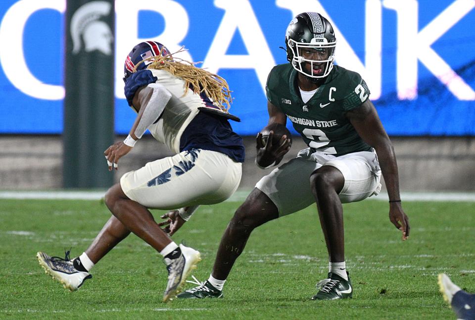 The Oregon defense is charged with trying to slow down quarterback Aidan Chiles (2) and the Michigan State offense Friday night at Autzen Stadium.