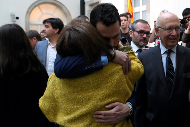 Catalan parliament speaker Roger Torrent hugs Blanca Bragulat, wife of jailed Catalan separatist Jordi Turull, at the end of Saturday's session