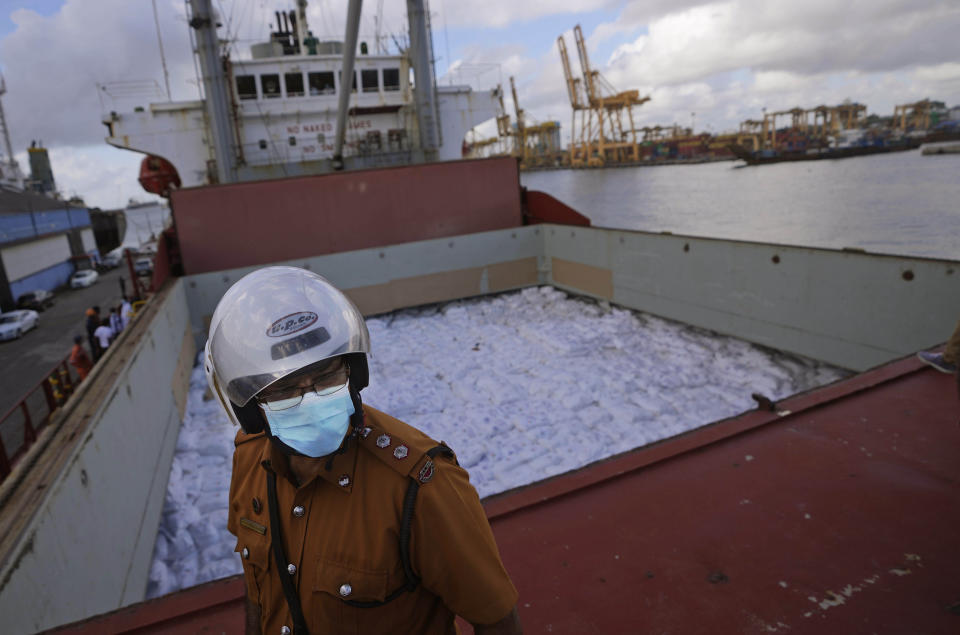 A Sri Lankan port worker stands on a ship that carried emergency supplies granted as humanitarian aid by India government to Sri Lankan people at a port in Colombo, Sri Lanka, Sunday, May 22, 2022. (AP Photo/Eranga Jayawardena)