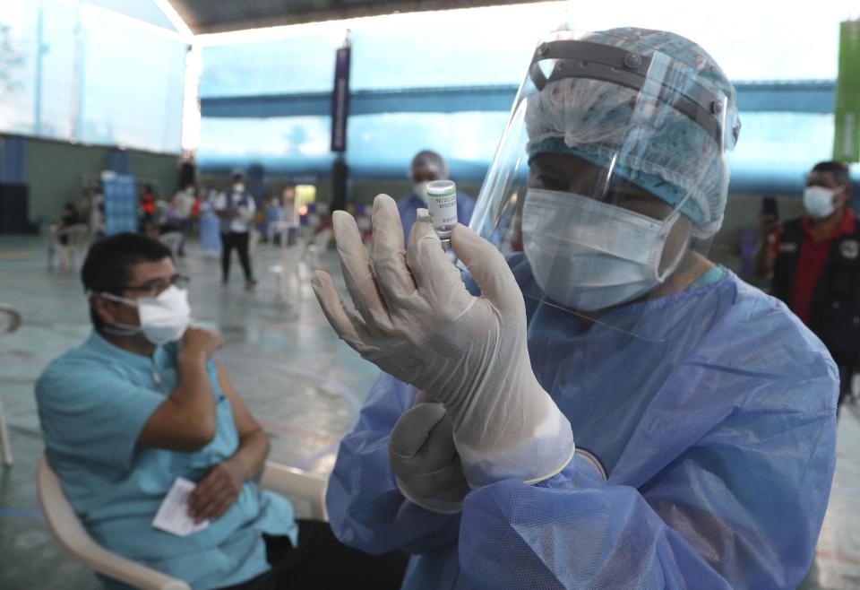 A nurse prepares a dose of China's Sinopharm vaccine during a priority COVID-19 vaccination of health workers at a public hospital in Lima, Peru, Wednesday, Feb. 10, 2021. Peru received its first shipment of COVID-19 vaccines on Sunday night. (AP Photo/Martin Mejia)