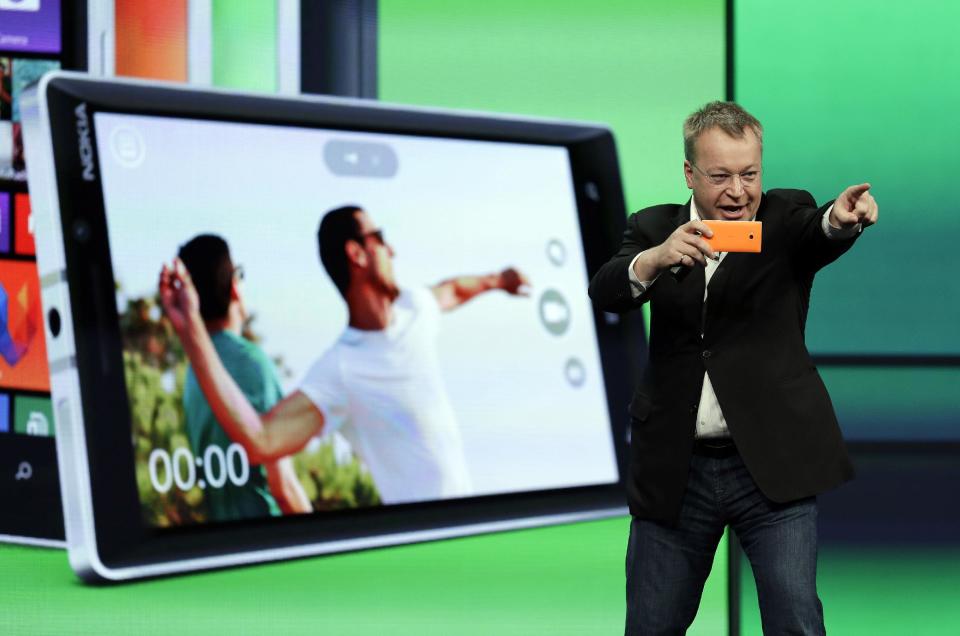 Stepen Elop, executive vice president of Nokia, demonstrates the picture taking ability of the new Nokia Lumia 930 phone during a keynote address of the Microsoft Build Conference Wednesday, April 2, 2014, in San Francisco. Microsoft kicked off its annual conference for software developers, with new updates to the Windows 8 operating system and upcoming features for Windows Phone and Xbox. (AP Photo/Eric Risberg)