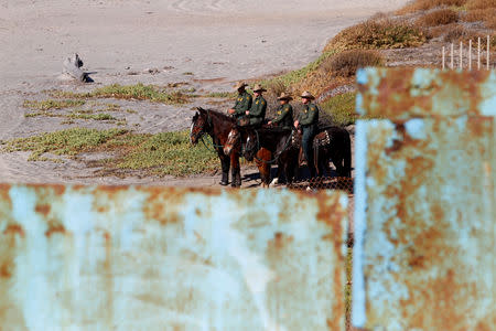 U.S. border patrol stand behind the border fence between Mexico and the United States, as seen from Tijuana, Mexico November 14, 2018. REUTERS/Jorge Duenes