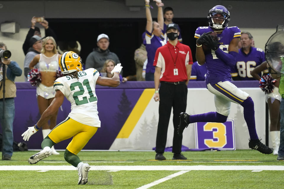 Minnesota Vikings wide receiver Justin Jefferson, right, catches a 23-yard touchdown pass ahead of Green Bay Packers cornerback Eric Stokes (21) during the second half of an NFL football game, Sunday, Nov. 21, 2021, in Minneapolis. The Vikings won 34-31. (AP Photo/Jim Mone)