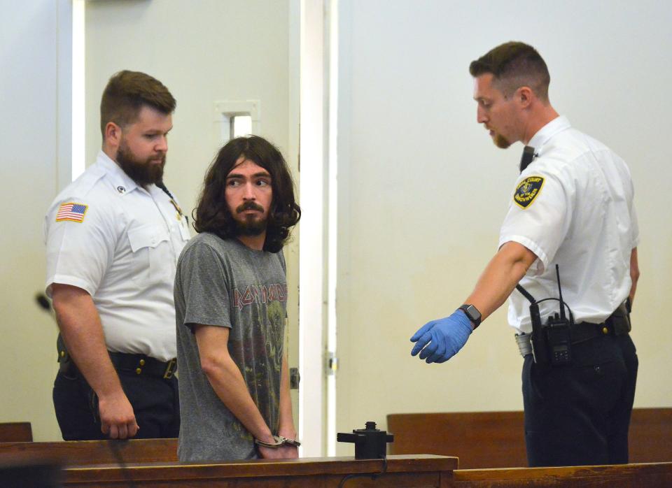 Justin Moreira looks back to his parents as he is escorted from the courtroom arraignment in Barnstable District Court Monday afternoon. He was arrested Saturday by Barnstable police for threatening to commit a school shooting. Merrily Cassidy/Cape Cod Times