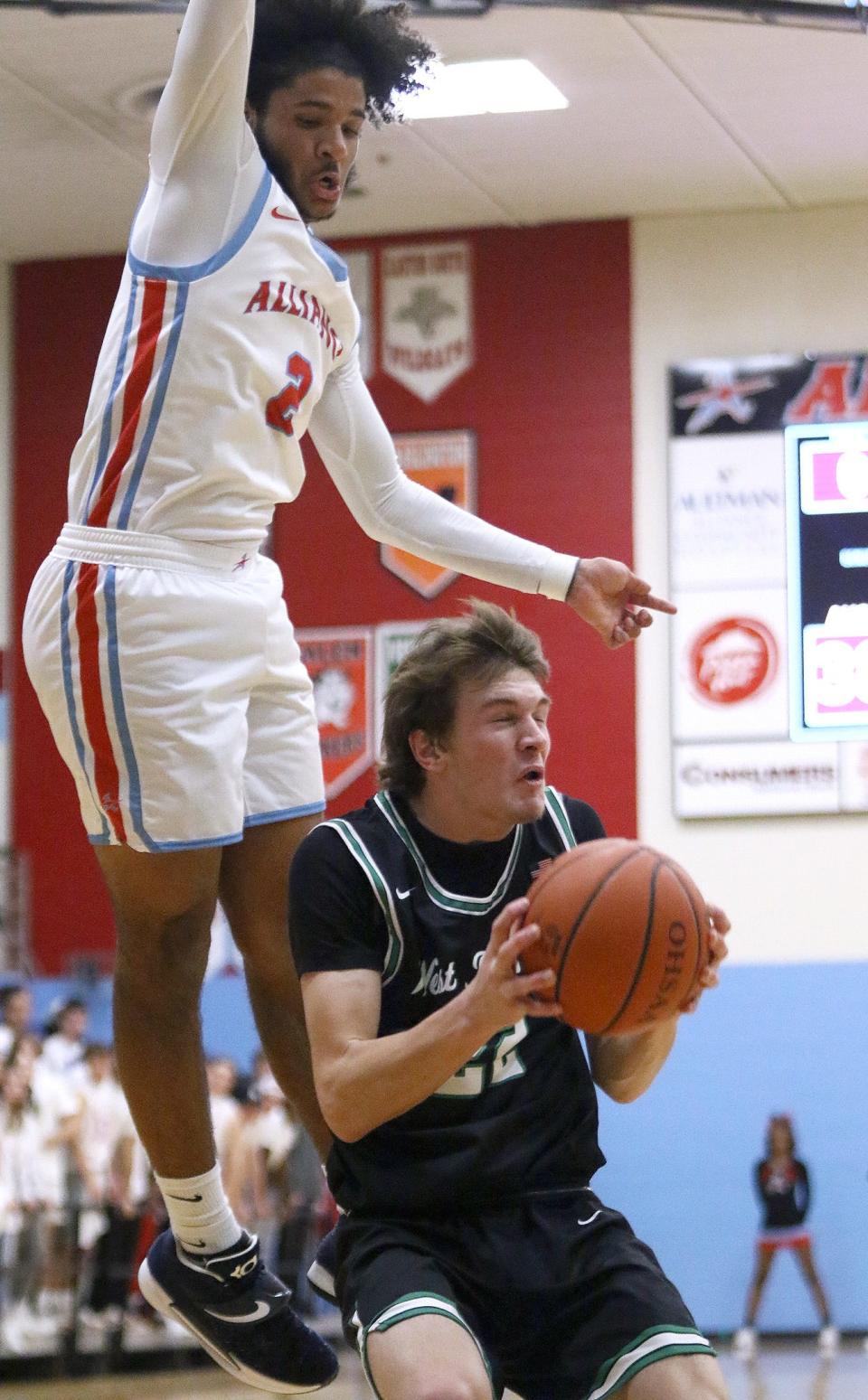 Alliance's K'Vaughn Davis, left, leaps, West Branch's Dru DeShields with the ball during action at Alliance High School Tuesday, January 18, 2022.
