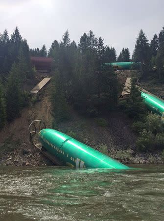 Three Boeing 737 fuselages lie on an embankment on the Clark Fork River after a BNSF Railway Co train derailed Thursday near Rivulet, Montana in this picture taken July 4, 2014. REUTERS/Andrew Spayth