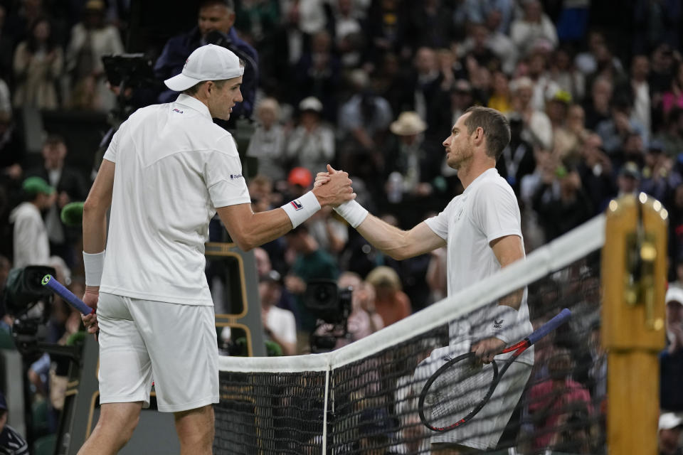 John Isner of the US shakes hands with Britain's Andy Murray after defeating him in their singles tennis match on day three of the Wimbledon tennis championships in London, Wednesday, June 29, 2022. (AP Photo/Alastair Grant)