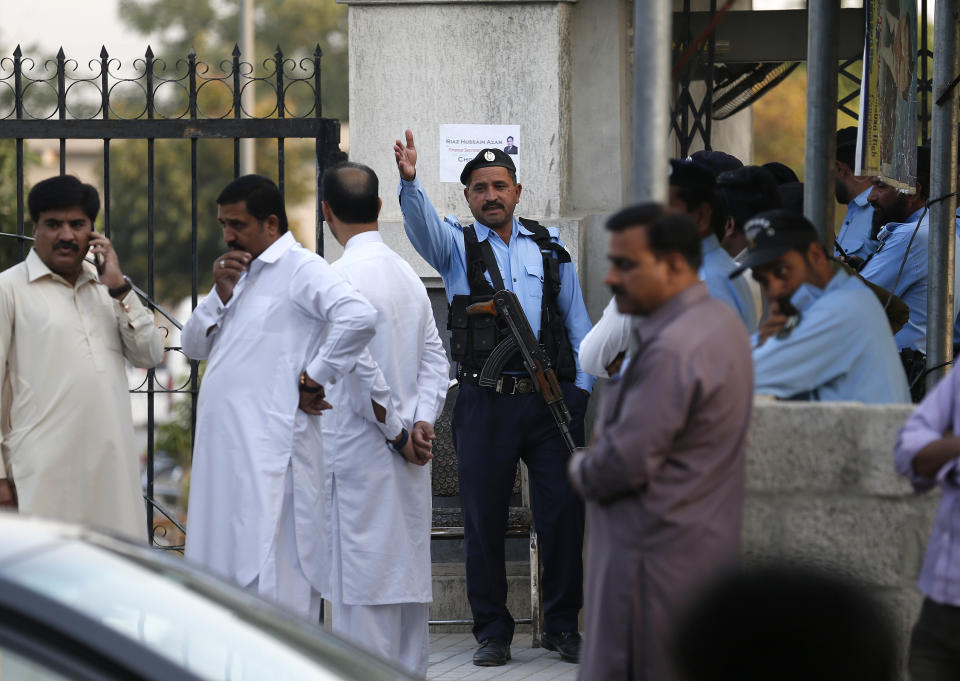 A Pakistani police officer remove the supporters of Pakistan's ailing former Prime Minister Nawaz Sharif gather at an entrance of Islamabad High Court, in Islamabad, Pakistan, Saturday, Oct. 26, 2019. An Islamabad court is holding an emergency hearing to decide whether to free Sharif, convicted on money-laundering and corruption at charges. (AP Photo/Anjum Naveed)