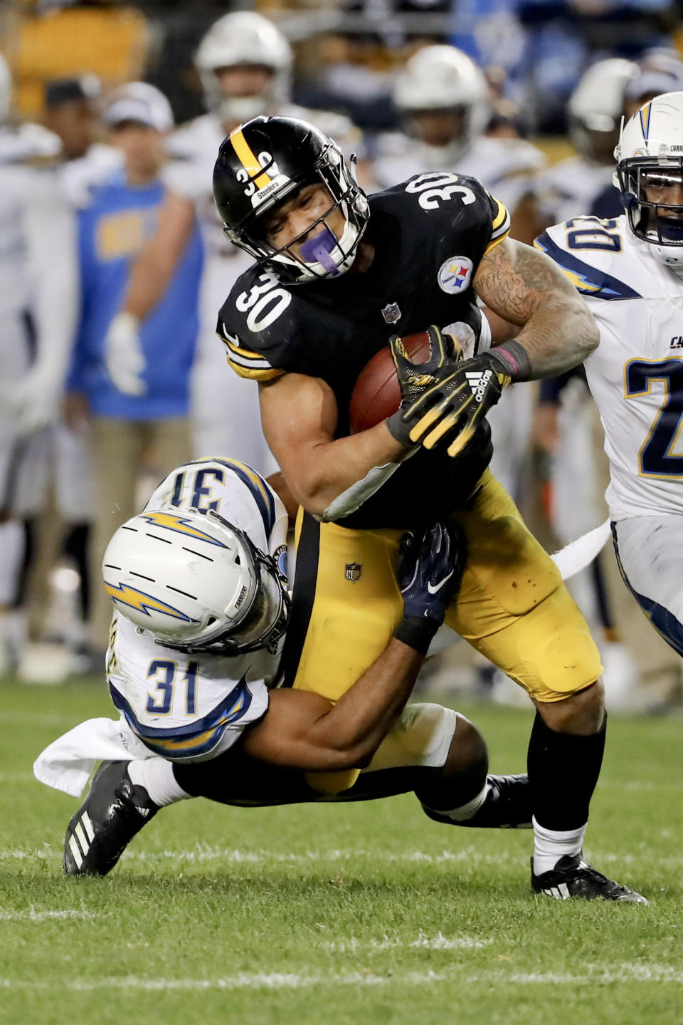 Pittsburgh Steelers running back James Conner (30) is injured as Los Angeles Chargers defensive back Adrian Phillips (31) tackles him in the second half of an NFL football game, Sunday, Dec. 2, 2018, in Pittsburgh. (AP Photo/Gene J. Puskar)