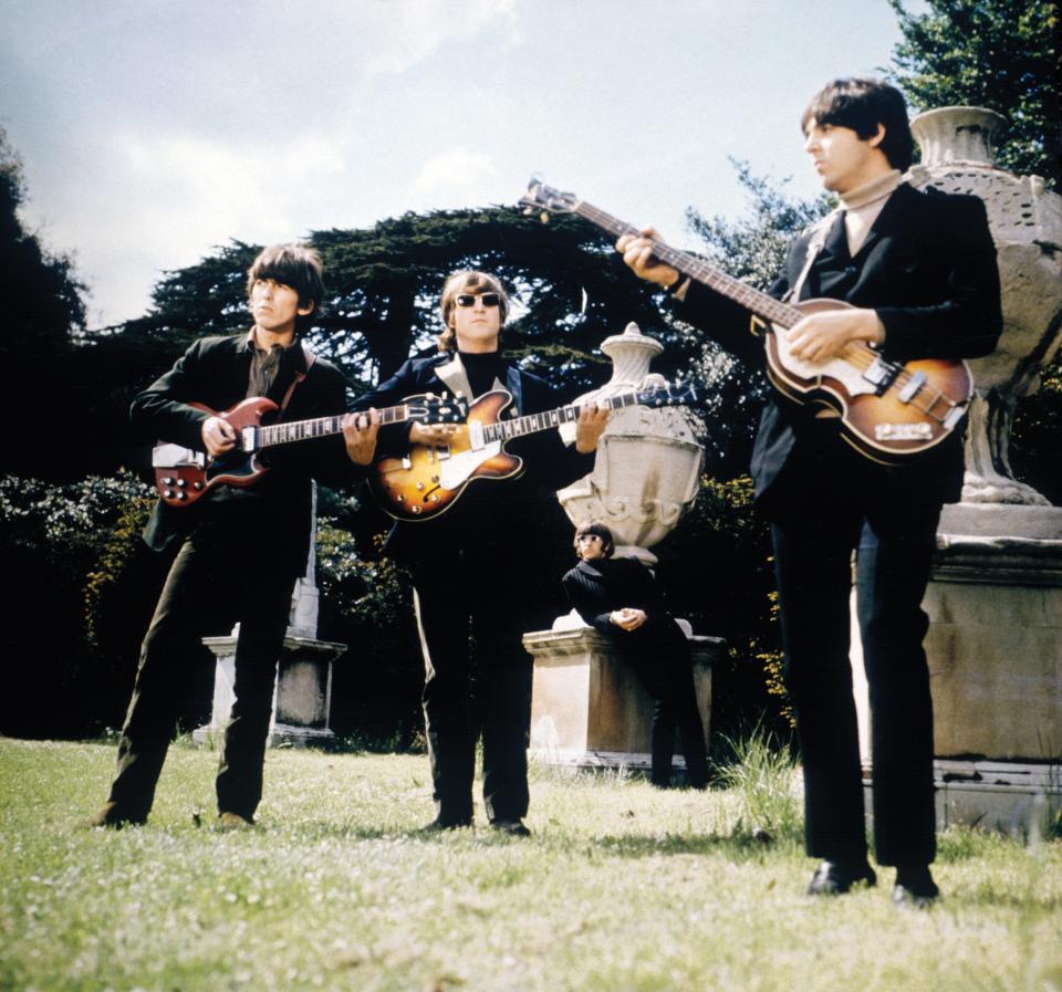 The Beatles (from left, George Harrison, John Lennon and Paul McCartney, with Ringo Starr in the background) at the gardens of Chiswick House, a villa in London, to film music videos for "Paperback Writer" and "Rain" on May 20, 1966.