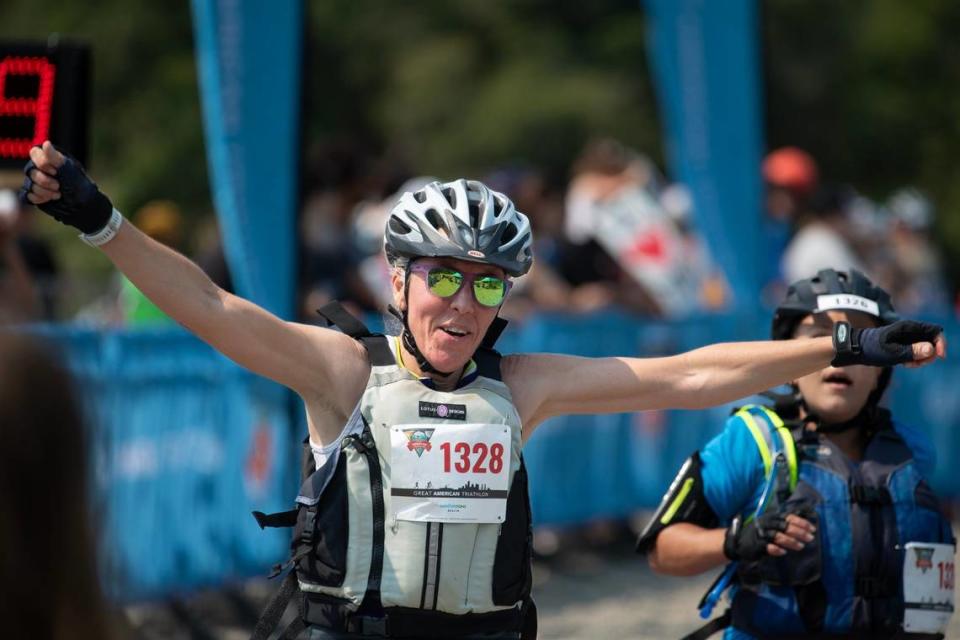 Jennifer Reents of Sacramento raises her arms after completing at the Great American Triathlon on Saturday, July 20, 2024.