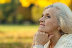 Senior woman walking in the park in autumn