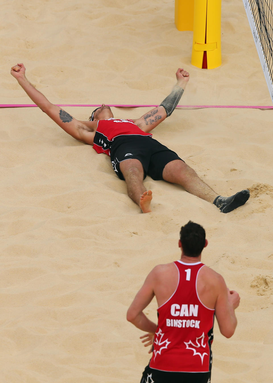 LONDON, ENGLAND - JULY 28: Joshua Binstock #1 and Martin Reader of Canada celebrate their victory against Great Britain during the Men's Beach Volleyball Preliminary Round on Day 1 of the London 2012 Olympic Games at Horse Guards Parade on July 28, 2012 in London, England. (Photo by Ryan Pierse/Getty Images)