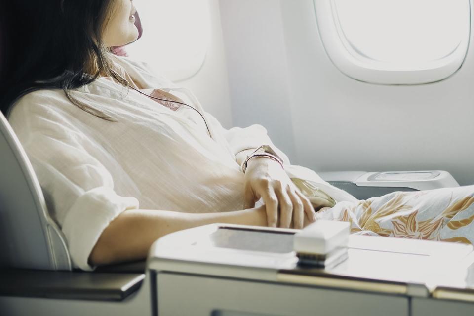 <p>Getty</p> A stock image of a woman on a airplane.