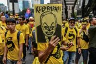 A protester holds a sign with a picture of then-Malaysian Prime Minister Najib Razak during a November 2016 rally calling for Razak's resignation, in Kuala Lumpur, Malaysia