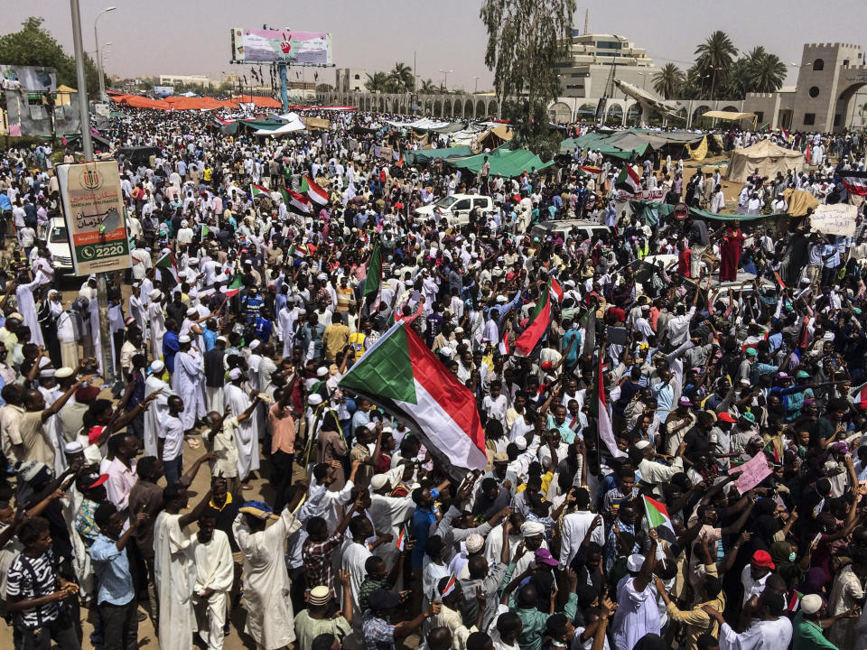 FILE - In this April 12, 2019 file photo, demonstrators rally in Sudan's capital, Khartoum. For the first time in three decades, Sudan has charted a path out of military rule following the formation of a power-sharing government by the pro-democracy movement and the generals who overthrew longtime autocrat Omar al-Bashir. But the fragile transition will be tested as leaders confront a daunting array of challenges. (AP Photo, File)