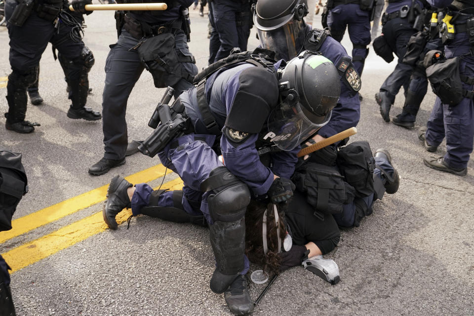 Police detain a protester, Wednesday, Sept. 23, 2020, in Louisville, Ky. A grand jury has indicted one officer on criminal charges six months after Breonna Taylor was fatally shot by police in Kentucky. The jury presented its decision against fired officer Brett Hankison Wednesday to a judge in Louisville, where the shooting took place. (AP Photo/John Minchillo)