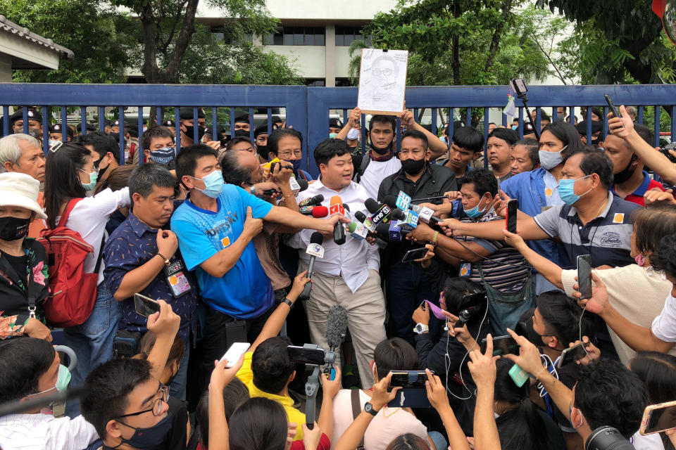 Protest leader Parit “Penguin” Chiwarak, center, is surrounded by journalists outside the criminal court after he was released on bail Saturday, Aug. 15, 2020 in Bangkok, Thailand. Parit was arrested by police Friday on a sedition charge in connection with a July 18 protest. (AP Photo/Busaba Sivasomboon)