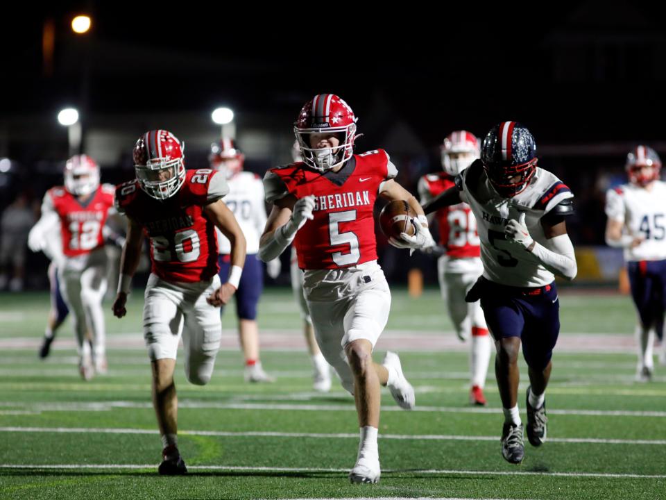 A.J. Winders returns an interception for a first-quarter touchdown as Ryan Perry tries to chase him down during Sheridan's 34-27 win against Columbus Hartley in a Division IV, Region 15 semifinal on Friday at Newark's White Field.