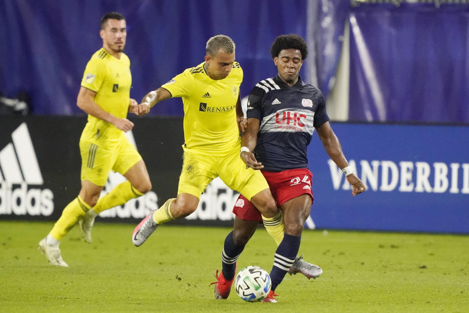 Nashville SC forward Randall Leal, center, and New England Revolution defender DeJuan Jones (24) battle for the ball during the first half of an MLS soccer match Friday, Oct. 23, 2020, in Nashville, Tenn. (AP Photo/Mark Humphrey)