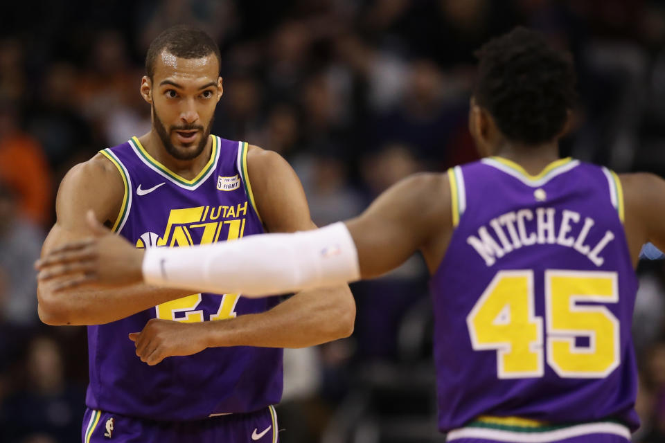 PHOENIX, ARIZONA - MARCH 13:  Rudy Gobert #27 of the Utah Jazz is congratulated by Donovan Mitchell #45 after scoring against the Phoenix Suns during the first half of the NBA game at Talking Stick Resort Arena on March 13, 2019 in Phoenix, Arizona. (Photo by Christian Petersen/Getty Images)