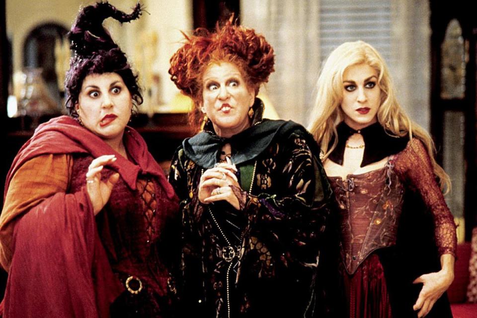 Three witches stand together in a still from Hocus Pocus. 