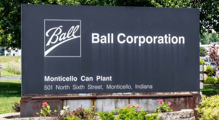An image of a black sign surrounded by flowers and trees that has the white text "Ball" with an underline in a white box, the text "Ball Corporation" in white, and the text "Monticello Can Plant" 501 North Sixth Street, Monticello, Indiana below in a small white font.