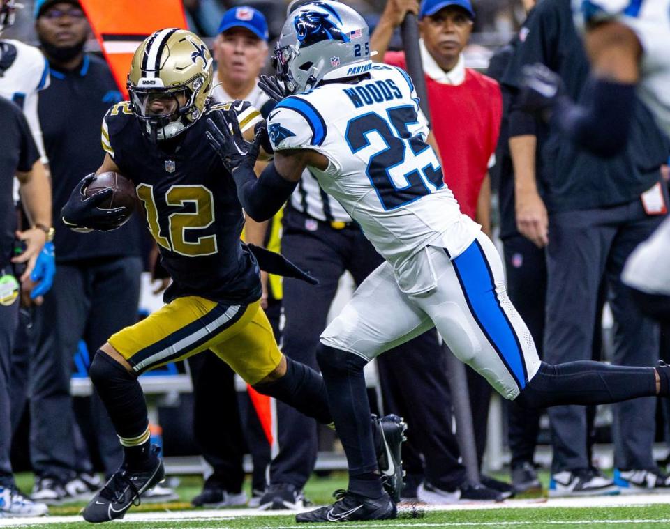 Carolina Panthers safety Xavier Woods (25) pushes New Orleans Saints wide receiver Chris Olave (12) out of bounds on a pass play during the first half at the Caesars Superdome.