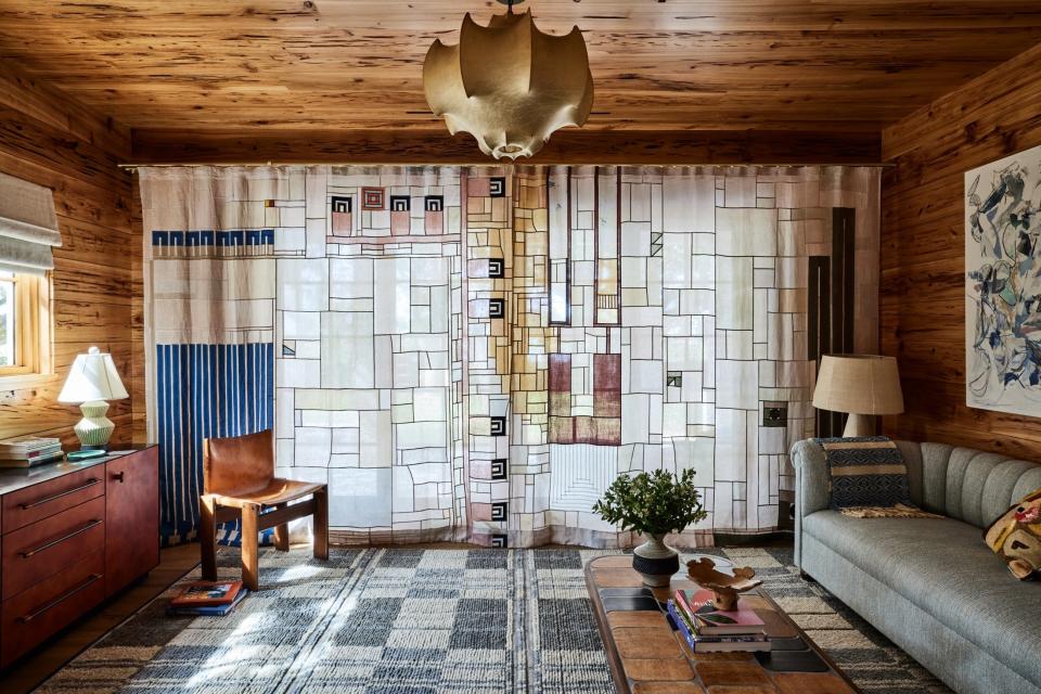 For this beach house in Ponte Vedra Beach, Florida, Bunsa Studio added cypress paneling and a commissioned Bojagi-style curtain by Adam Pogue to a study off the primary bedroom.