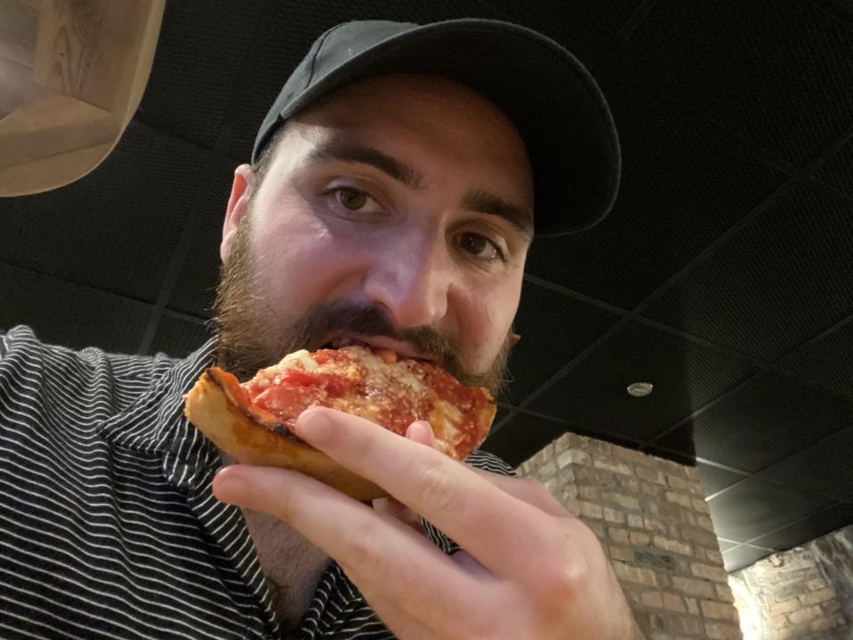 taking a bite of deep dish pizza at lou malnati's in chicago