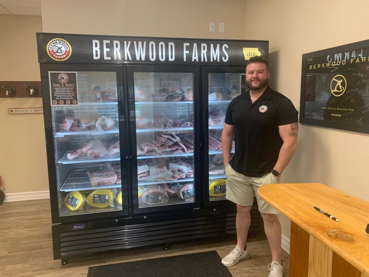 Jake Mooers in front of a case of purebred Berkshire pork at the co-op's Des Moines store.