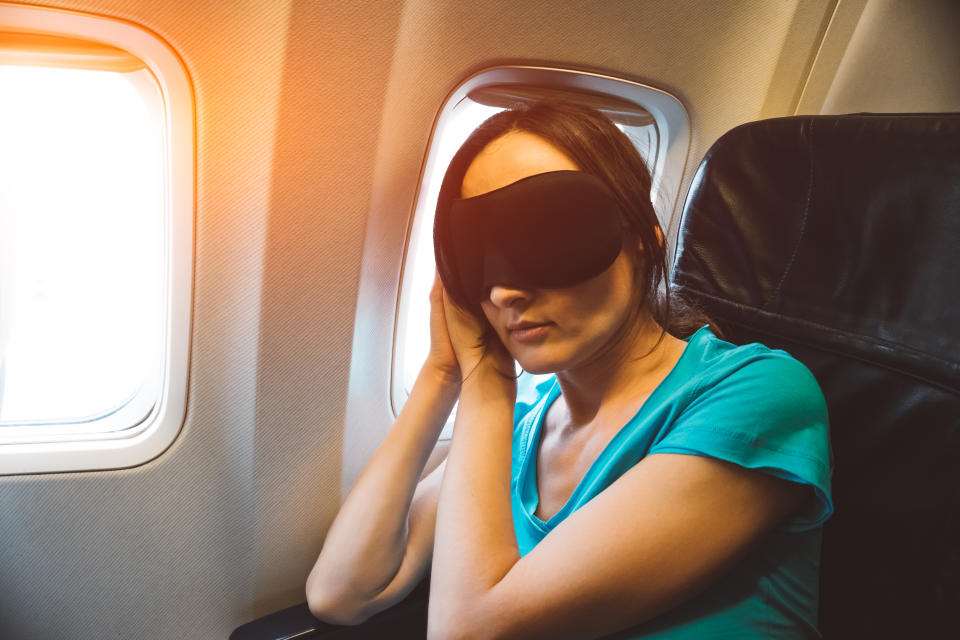 Una mujer duerme mientras viaja en avión. (Foto: Getty Images).