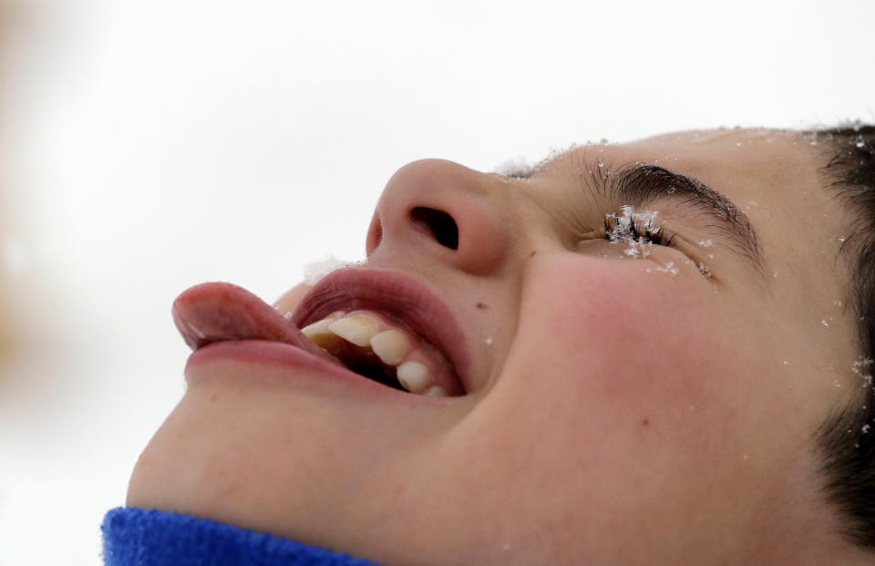 A snowflake lands on Joshua Blau's eye as he tries to catch them in his mouth while heavy snow falls Monday, Feb. 11, 2019, in Seattle. Schools closed across Washington state and the Legislature canceled all hearings Monday with winter snowstorms pummeling the Northwest again as a larger weather system wreaked havoc in the region and even brought snow to Hawaii. (AP Photo/Elaine Thompson)