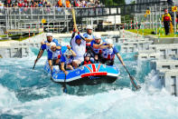 Zachary Franklin carries the Olympic Flame on a raft down the Lee Valley White Water Centre.