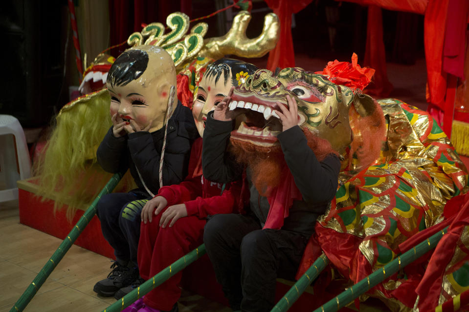 Children get ready for a parade during the Chinese community celebrations of the Lunar New Year, the year of the Rooster, in Madrid, Spain Saturday Jan. 28, 2017. (AP Photo/Paul White)