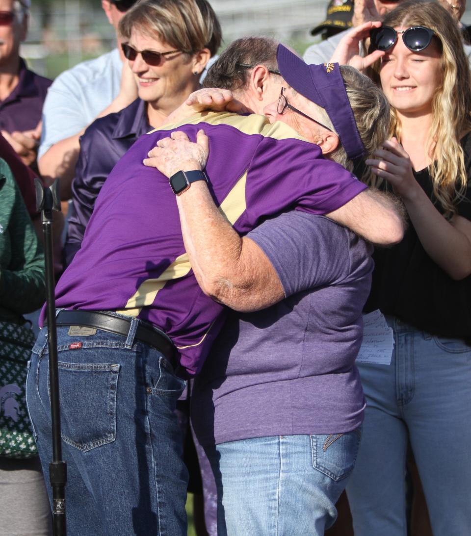 Judy Recker (right) hugs Reggie Talbot, who spoke during a ceremony naming the Fowlerville track and field complex in her honor on Tuesday, May 9, 2023.